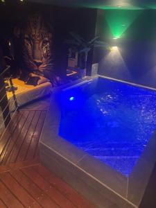 a hot tub in a room with a tiger head at Nyx suite d’exception in Dijon