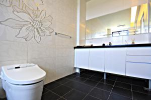 une salle de bain avec des toilettes blanches et un lavabo dans l'établissement Woo Shiba House, à Wujie