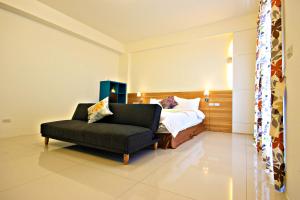 une chambre avec un lit, un canapé et une chaise dans l'établissement Woo Shiba House, à Wujie