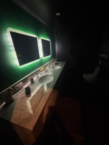 a bathroom with two sinks and a green light at Nyx suite d’exception in Dijon