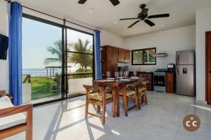 une cuisine avec une table et des chaises ainsi qu'une grande fenêtre dans l'établissement Casa del Angel Tomatal, a beachfront house, à Puerto Escondido