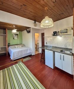 a kitchen and a bedroom with a bed in a room at Morada das Pedras in Florianópolis