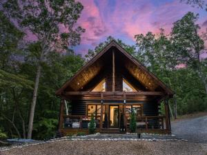 une cabane en rondins dans les bois avec un coucher de soleil dans l'établissement Cozy Chic Retreat Hot Tub, King Beds, Fire Pit, à Morganton