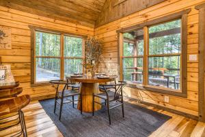 une salle à manger avec une table et des chaises dans une cabine dans l'établissement Cozy Chic Retreat Hot Tub, King Beds, Fire Pit, à Morganton