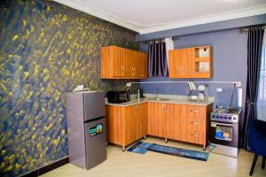 a kitchen with a wall mural of fruit on the wall at Blaize Affaire apartments in Kampala +1 photo