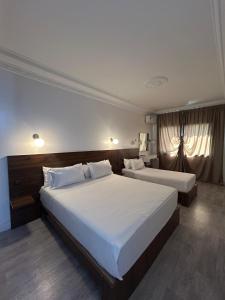 a hotel room with two beds with white sheets at Crystal hotel in Tangier
