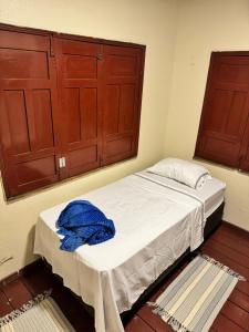 a small bedroom with a bed with wooden cabinets at Casa de Temporada em Alter do Chão in Alter do Chao