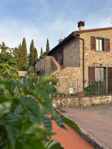 une maison en briques avec une clôture devant elle dans l'établissement Under The Tuscan Sun, à Arezzo