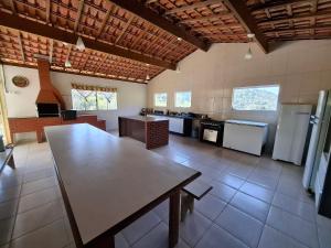 Sítio com 07 dormitórios, piscina e jogos LT0042 في Bairro dos Soares: مطبخ كبير مع طاولة في منتصفها