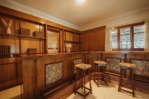 un bar in una stanza con pareti e sgabelli in legno di Hermosa Mansión-Parque inigualable-Pileta y AA a Chacras de Coria