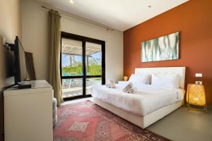 a bedroom with a bed and a large window at Staylish Villas in Joubal Lagoon El Gouna in Hurghada