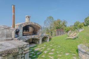 a stone oven in a yard with a grass field at Apartment Marta Slovenia Natures - Happy Rentals in Levpa