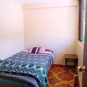 クスコにあるCocaRunaWasiの枕が置かれたベッドのある寝室