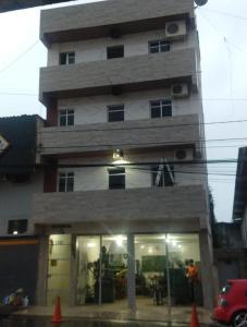 ein hohes Gebäude mit Menschen davor in der Unterkunft Kitnet encantador no centro de campina grande -PB in Campina Grande