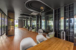a conference room with a wooden table and chairs at Bellevue Lagoon Premium Apart Hotel by TropicLook in Laguna Phuket