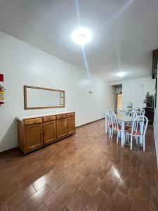 a dining room with a table and white chairs at Hotel Sagrada Família in Montes Claros
