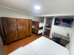 タルマにあるPrivate Apartment Autonomous Access Fiber Optic Wifiのベッドと壁にテレビが掛かった寝室