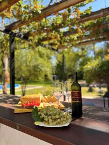 un tavolo con un piatto di cibo e una bottiglia di vino di Hermosa Mansión-Parque inigualable-Pileta y AA a Chacras de Coria
