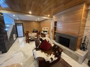 a living room with a fireplace and a chair at Villa Lumiere-Luxury Retreat with Private Spa and Garden in Ifrane