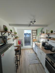 a kitchen with white cabinets and a table and a window at Traumwohnung über den Dächern Rüttenscheids in Essen