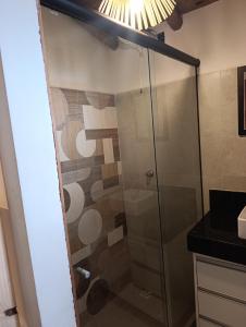 a shower with a glass door in a bathroom at Casa Xandó in Porto Seguro