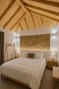 a bedroom with a large white bed and wooden ceilings at Uíma River House 