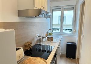 a kitchen with a sink and a stove top oven at Fleur Bohème - Hypercentre République - Parking in Le Mans