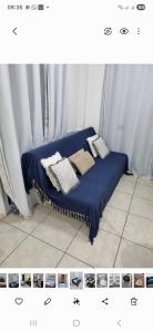 a bed with a blue blanket and pillows on it at Apartamento na praia de Jatiúca com piscina e área de lazer in Maceió