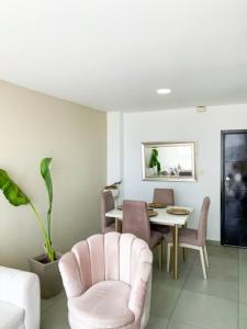 - un salon avec une table et une chaise rose dans l'établissement Espacioso Apto Moderno! Excelente Ubicación Norte de Barranquilla, à Barranquilla