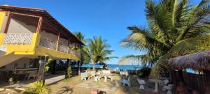 a resort with a patio with a view of the ocean at Pousada Veruschka Santiago in Maragogi