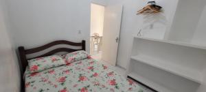 a small bedroom with a bed with flowers on it at Pousada Veruschka Santiago in Maragogi