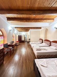 een grote kamer met vier bedden en een bureau en een tafel bij SHOXTUT Boutique in Bukhara