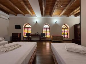 een kamer met 2 bedden en glas-in-loodramen bij SHOXTUT Boutique in Bukhara +75 foto's