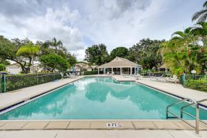 una piscina con sillas y una casa en Extended Stay in Estero Townhome with Lake Views!, en Estero