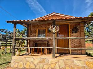 a small log cabin with a fence around it at Chalés Mirante da Serra in São Thomé das Letras