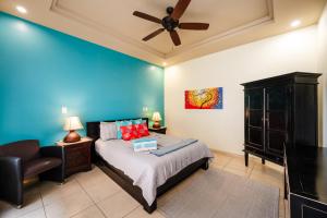 a bedroom with a bed and a ceiling fan at Oceanview In Town Huge Pool Beach Acss in Tamarindo +17 photos