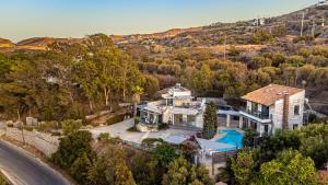 an aerial view of a house with a mountain at Elegant 2-Villa Stone Estate with Pool & Sea Views in Agia Pelagia