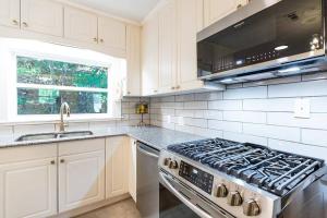 a white kitchen with a stove and a sink at The great retreat - 1 mile from the University in Fayetteville