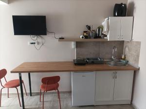 a kitchen with a table and two chairs and a sink at Katera S in Zemun