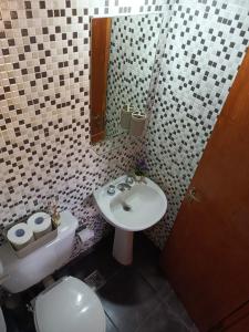 a bathroom with a sink and a toilet and a mirror at Cabaña La Chiquita in Villa Giardino