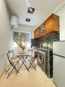 丹吉尔Cosy & Central, your Perfect City Spot的配有桌子和洗衣机的厨房