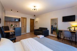 a bedroom with a bed and a living room with a couch at Сучасна студія в центрі - Харківська набережна 3-8 in Kharkiv