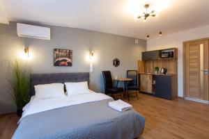 a bedroom with a large bed and a kitchen at Сучасна студія в центрі - Харківська набережна 3-8 in Kharkiv