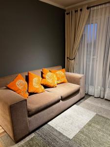 a couch with orange pillows in a living room at Departamento Centro Lagos in Temuco