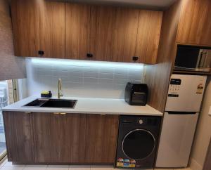 a small kitchen with a sink and a dishwasher at A Traveller's abode - Room 3 in Craigieburn +26 photos