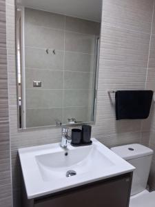un bagno con lavandino, WC e specchio di Nuevo Departamento Santa Rosa del Mar Coquimbo a Coquimbo