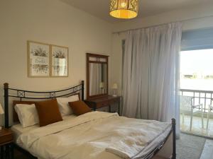 a bedroom with a bed and a large window at 1BDR chalet on direct swimming pool Einbay in Ain Sokhna