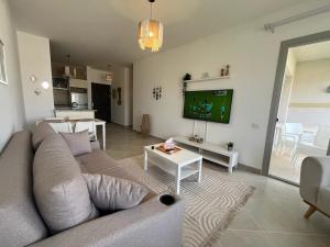 a living room with a couch and a tv at 1BDR chalet on direct swimming pool Einbay in Ain Sokhna