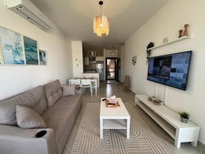 a living room with a couch and a table at 1BDR chalet on direct swimming pool Einbay in Ain Sokhna