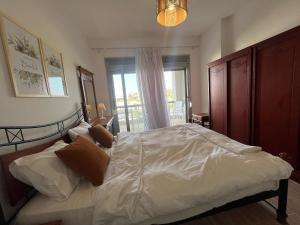 a bedroom with a large bed and a window at 1BDR chalet on direct swimming pool Einbay in Ain Sokhna